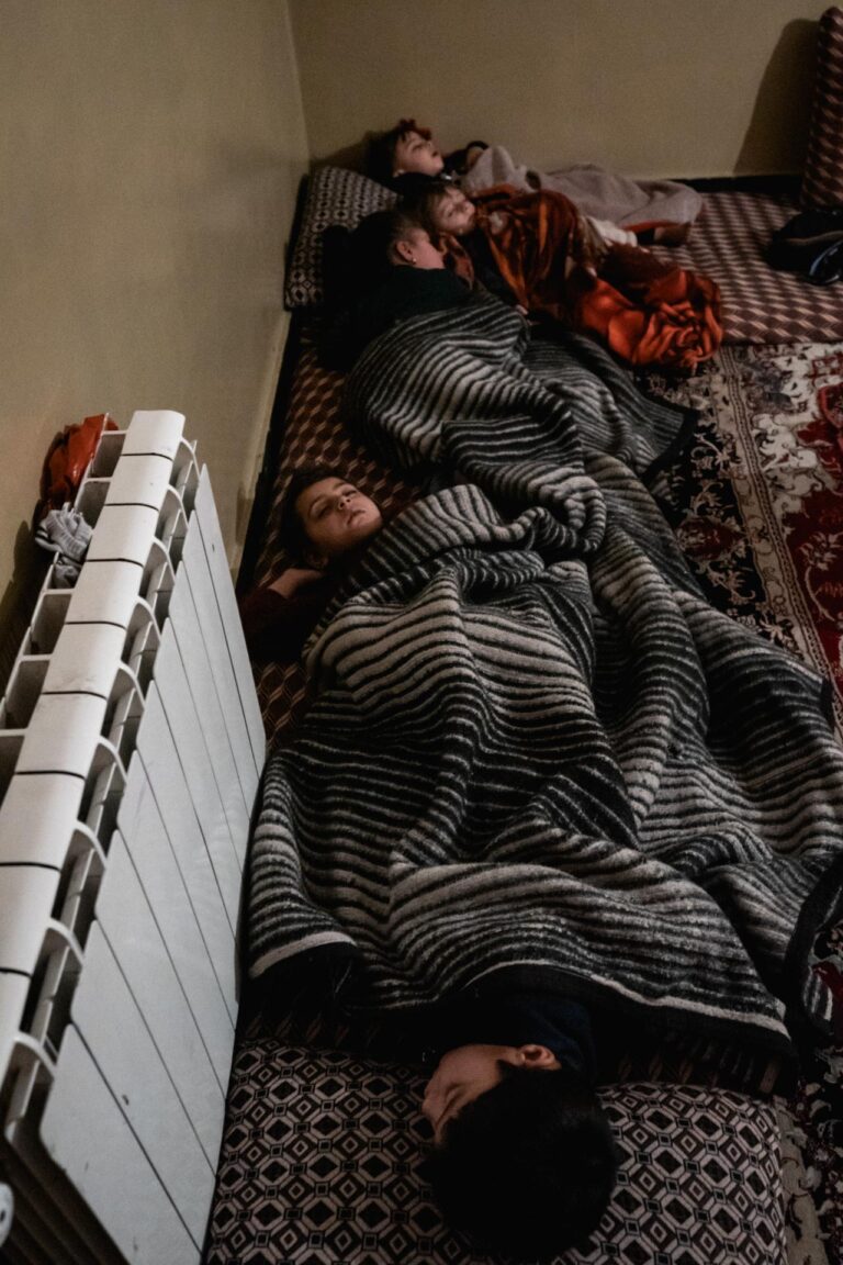 Afghan child sleeping under heavy blankets on the floor itself in Kabul, Afghanistan.