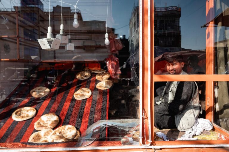 Close-up of a market stall selling bread inside a shop, viewed through a window in Kunduz, Afghanistan