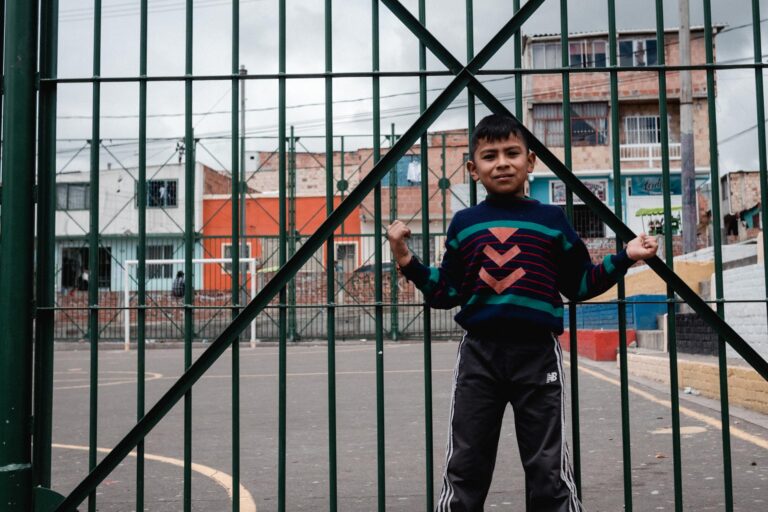 Two children lying on the floor, smiling and holding colorful books at a social foundation.