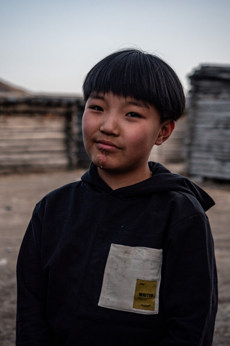 Young Mongolian boy posing against a concrete wall, Ulaanbaatar.