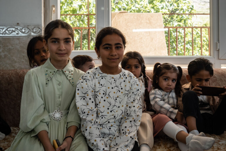 Young Kurdish girls sitting together in a peaceful home setting in Akre