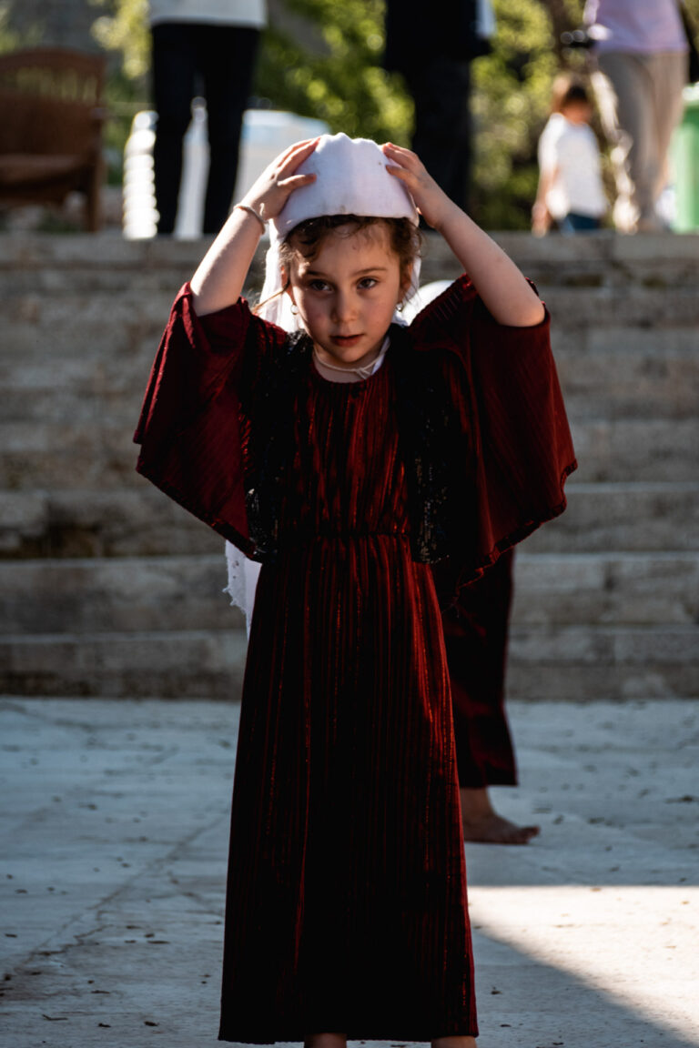 Young Yazidi girl in traditional dress posing confidently in Lalish temple