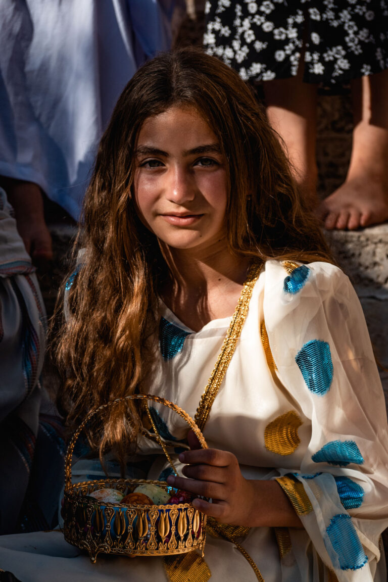 Close-up portrait of a smiling Yazidi woman inside the sacred Lalish temple