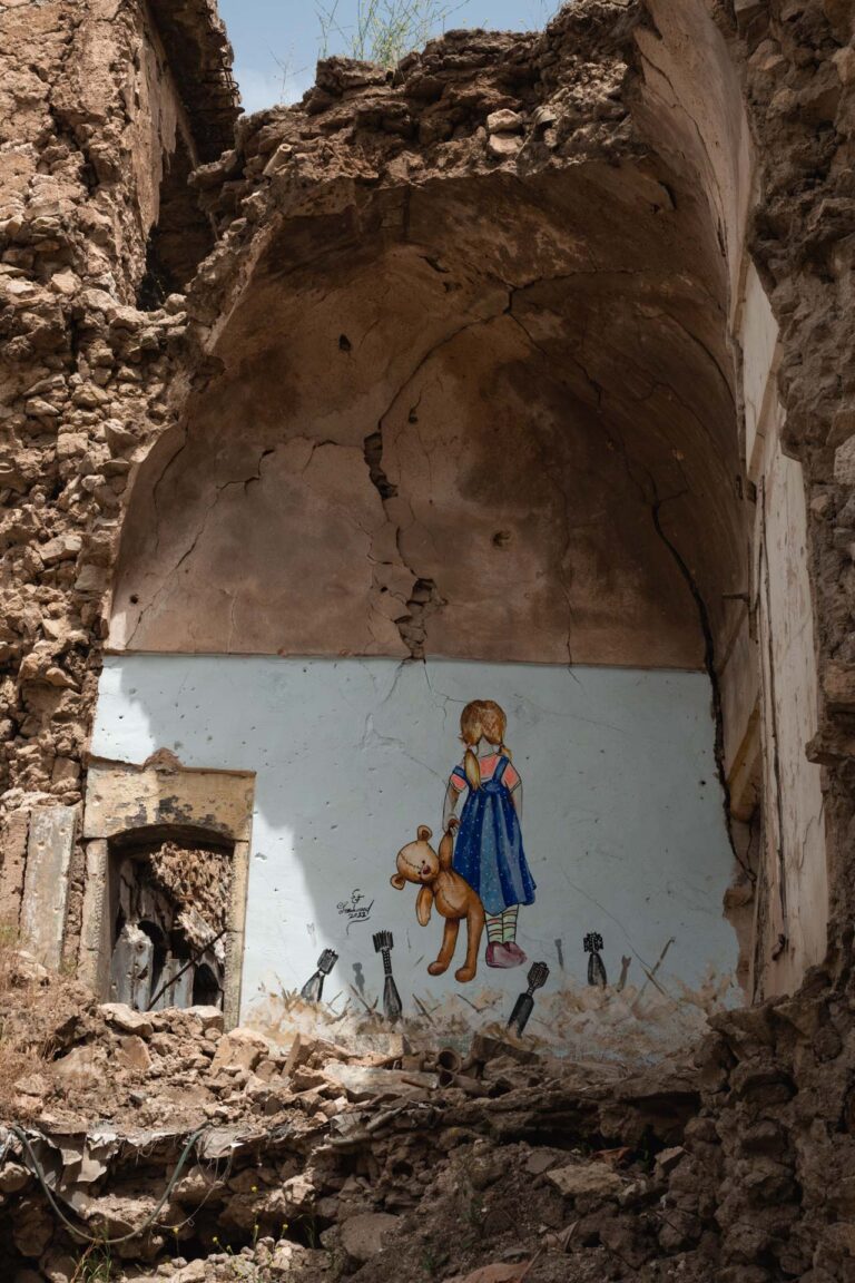 graffiti of a young girl standing in a ruined home, symbolizing loss in Mosul