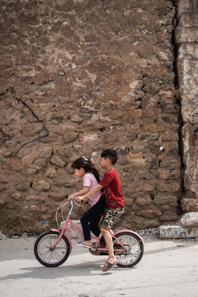 Cyclist riding alongside historic walls of Mosul, showcasing the city's heritage