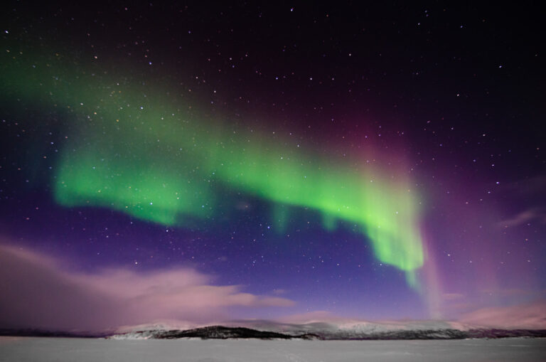 Northern lights dancing over snowy landscapes in Lapland, Sweden