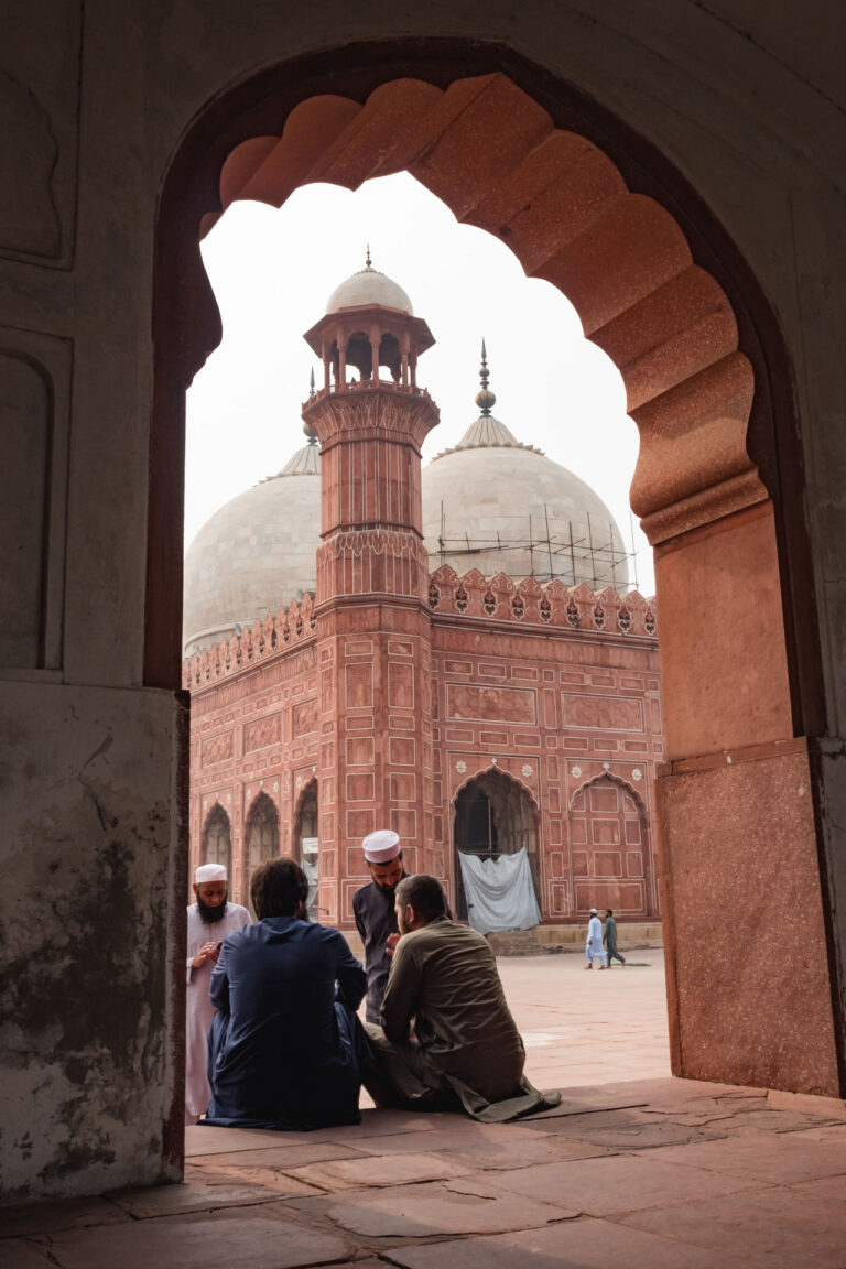 Silhouette of visitors at the grand entrance of the historic Badshahi Mosque in Lahore, Pakistan.
