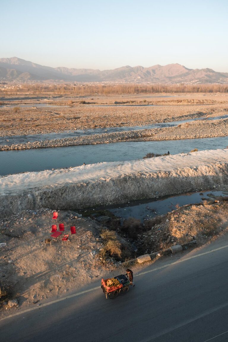 Stunning aerial view of a winding river flowing through the Swat valley’s rugged mountainous landscape in Pakistan.