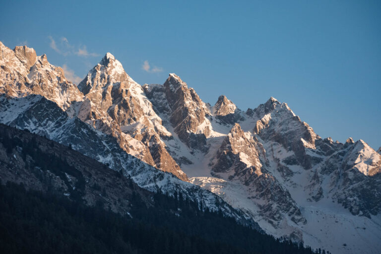 Breathtaking view of snow-capped peaks glowing at sunrise in Bayün, Swat valley, Pakistan.