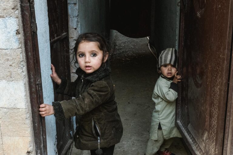 Pakistani children peeking from the door of a rustic mud-brick house in Madyan, Swat valley, Pakistan.