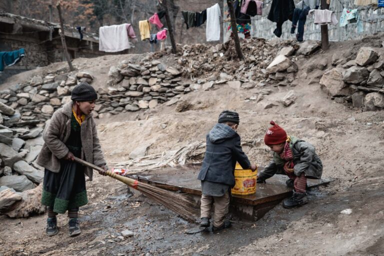 Group of Kalasha children playing in the mud, on a village terrace in Bumburet, Pakistan.