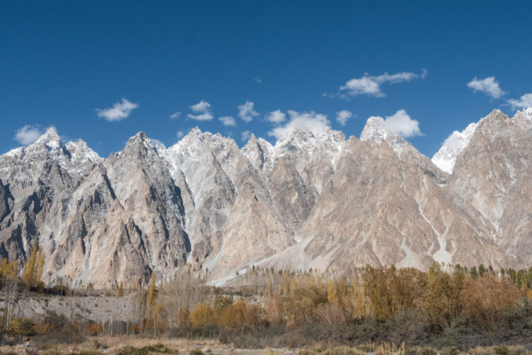 Dramatic peaks of the Passu Cones in Hunza Valley under a vibrant blue sky in northern Pakistan
