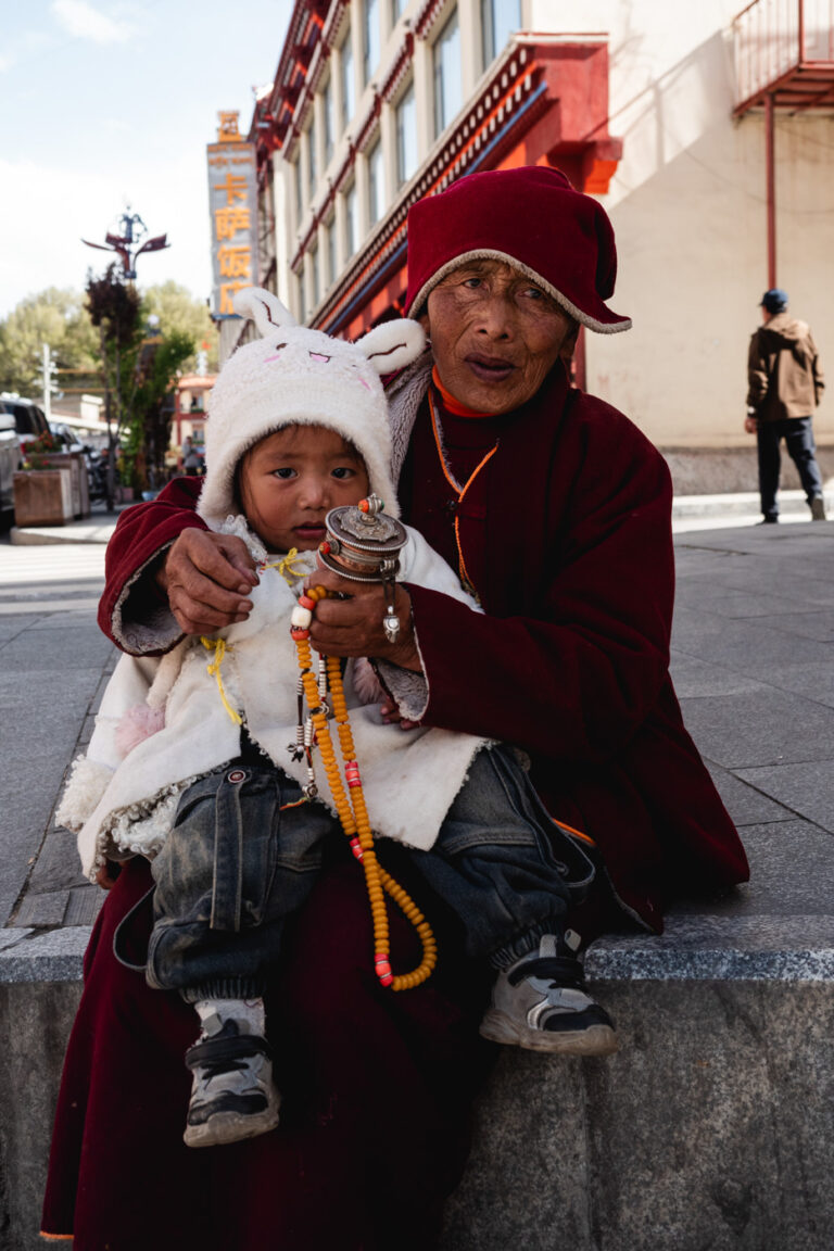 Tibetan woman with prayer beads and her granddaughter in Tibet China