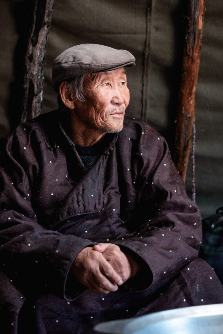 Tsaatan Mongolian man in fur hat staring from doorway