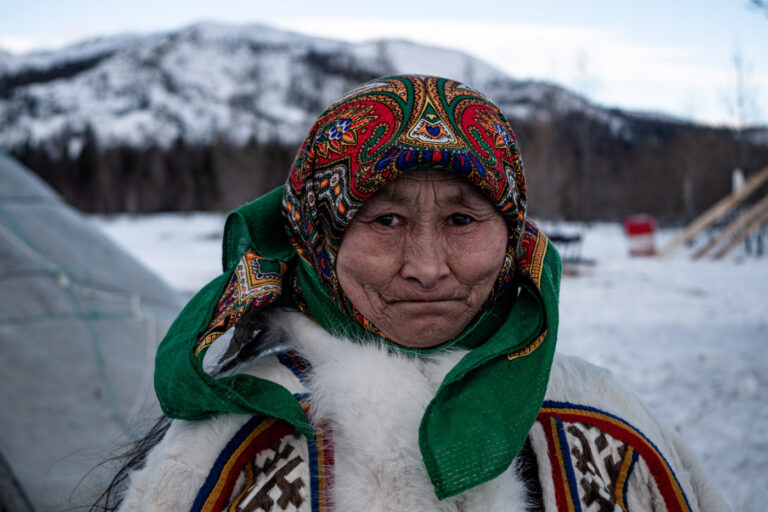 Close-up portrait of Nenets elder woman in reindeer fur, Siberian tundra, Russia.