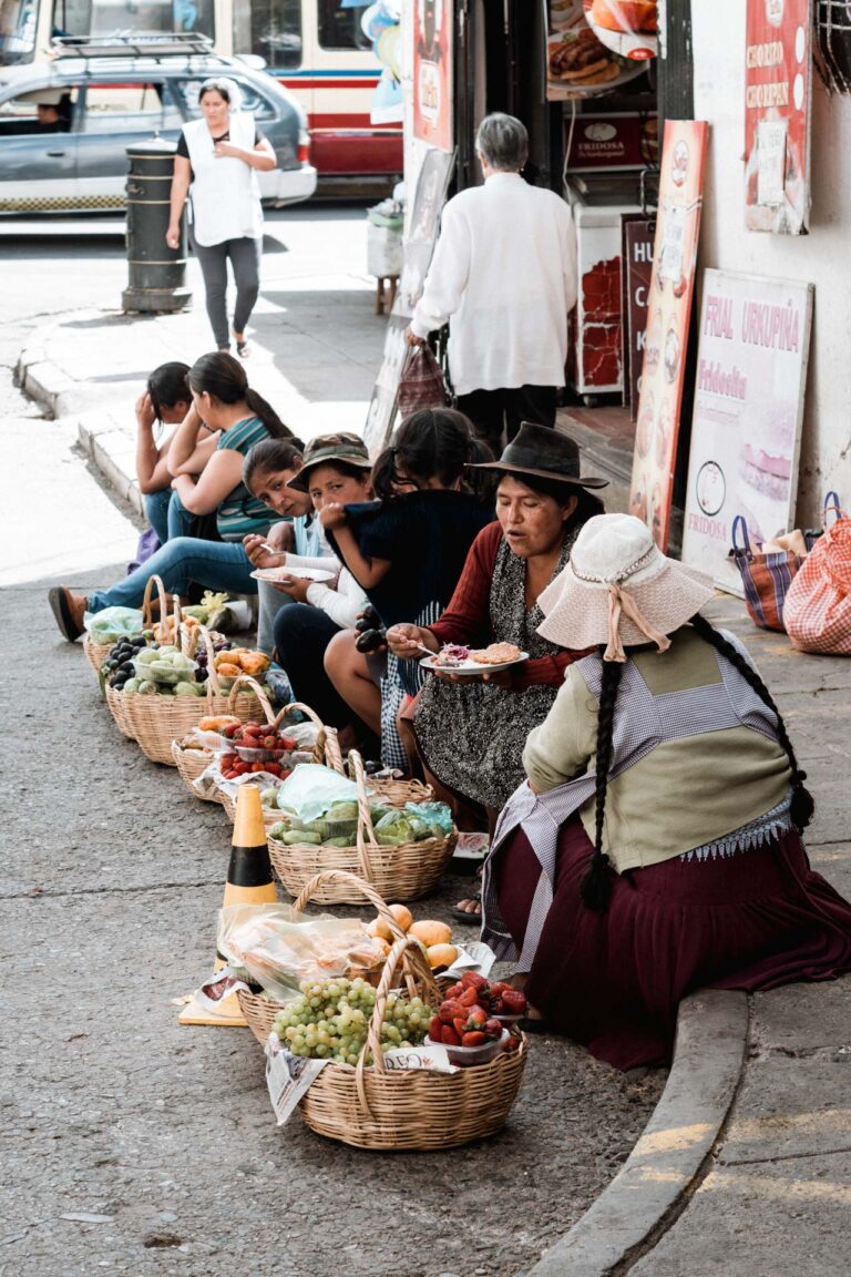 Bolivian women selling fruit and vegetables along a busy street market in Sucre.