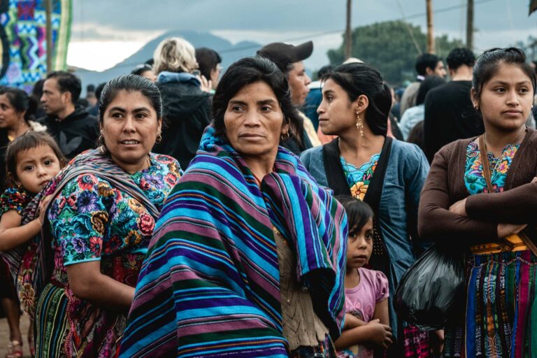 Group of Guatemalan women wearing colorful huipils at a festive gathering in Sumpango.