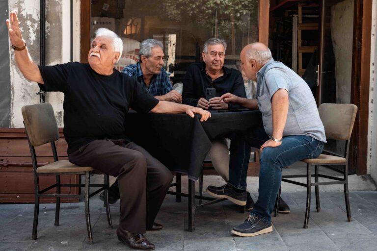 A group of four men sitting waiting for their tea in the Kurdish city of Mardin