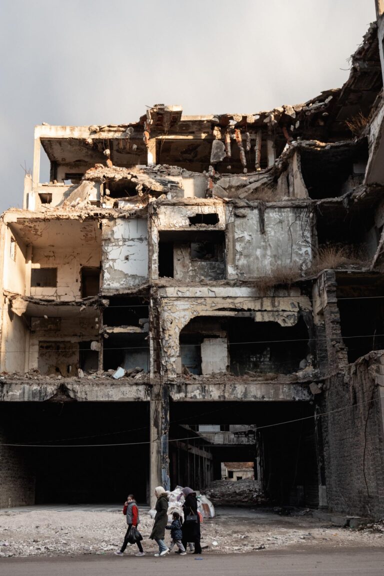 Partially destroyed building with exposed interiors in Homs, Syria.