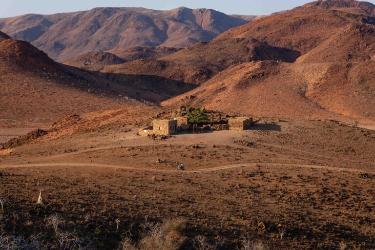 A cluster of small buildings in a vast, arid valley between Kelisan and Homhil.