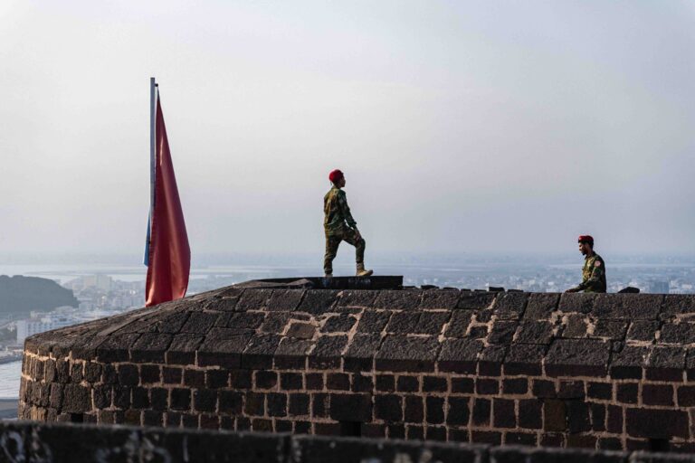 Soldiers standing on the stone ramparts of a historic fort in Aden, Yemen.